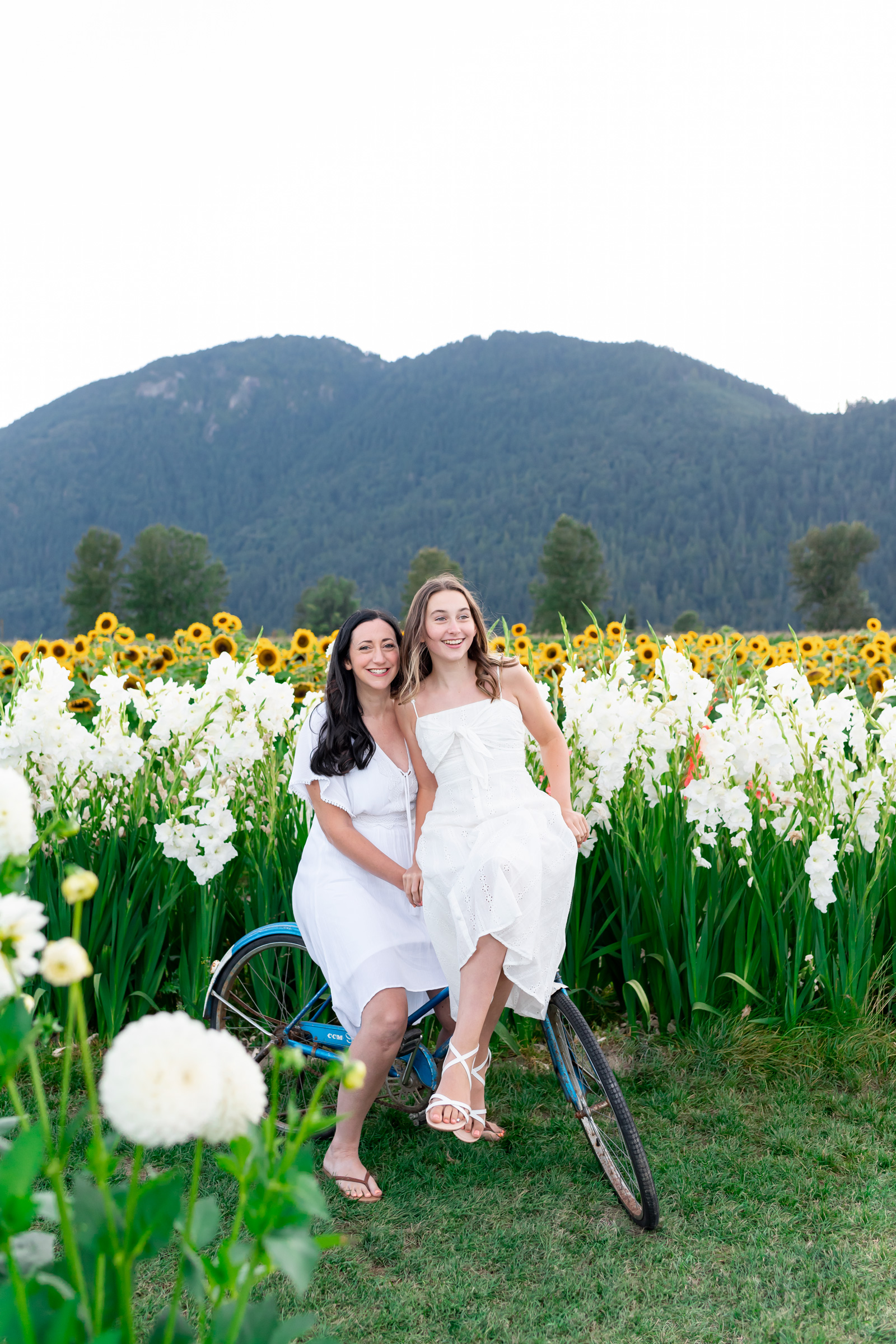 Candid playful authentic family photos, mother and daughter riding a bicycle