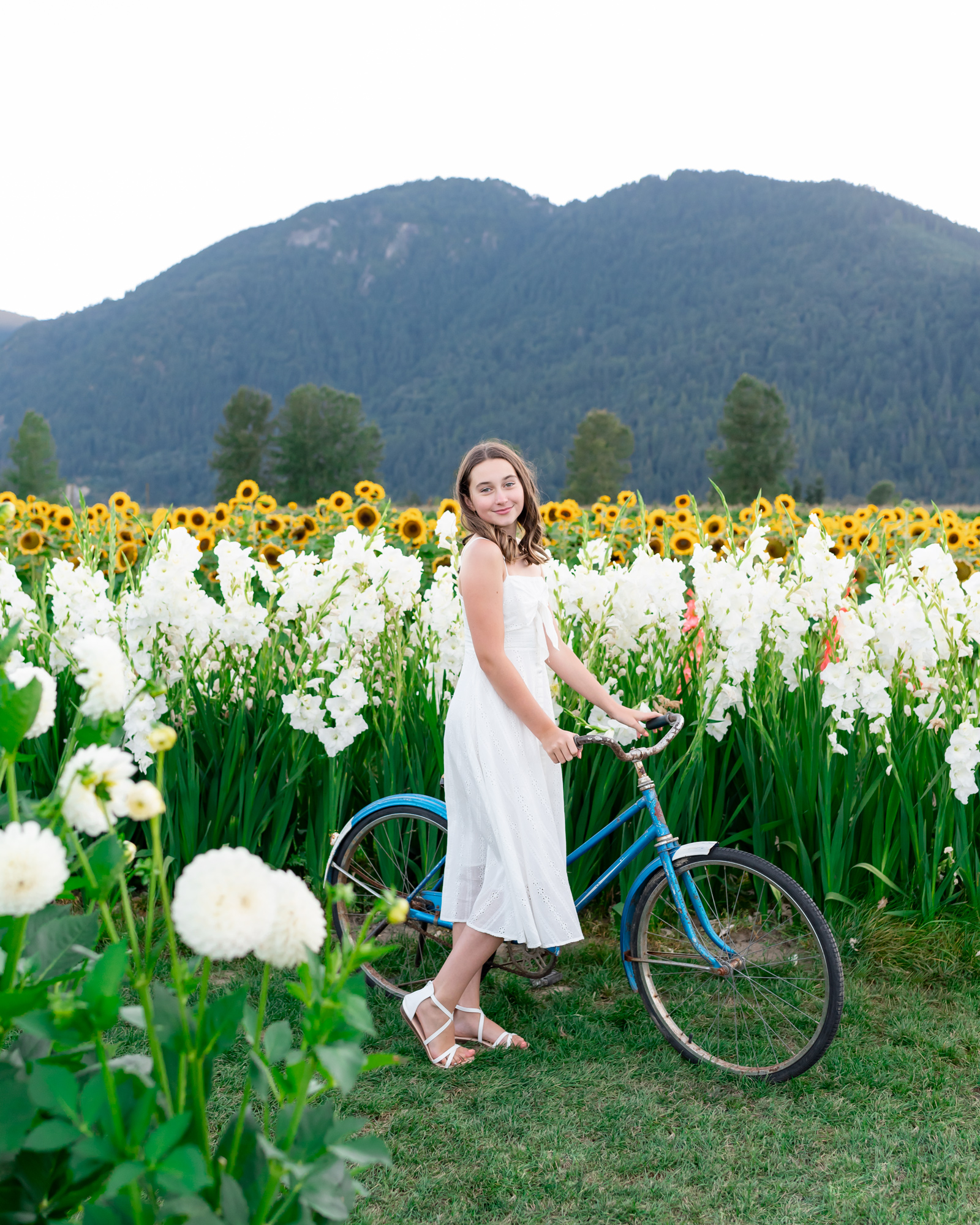 Teen with vintage bicycle in a flower field