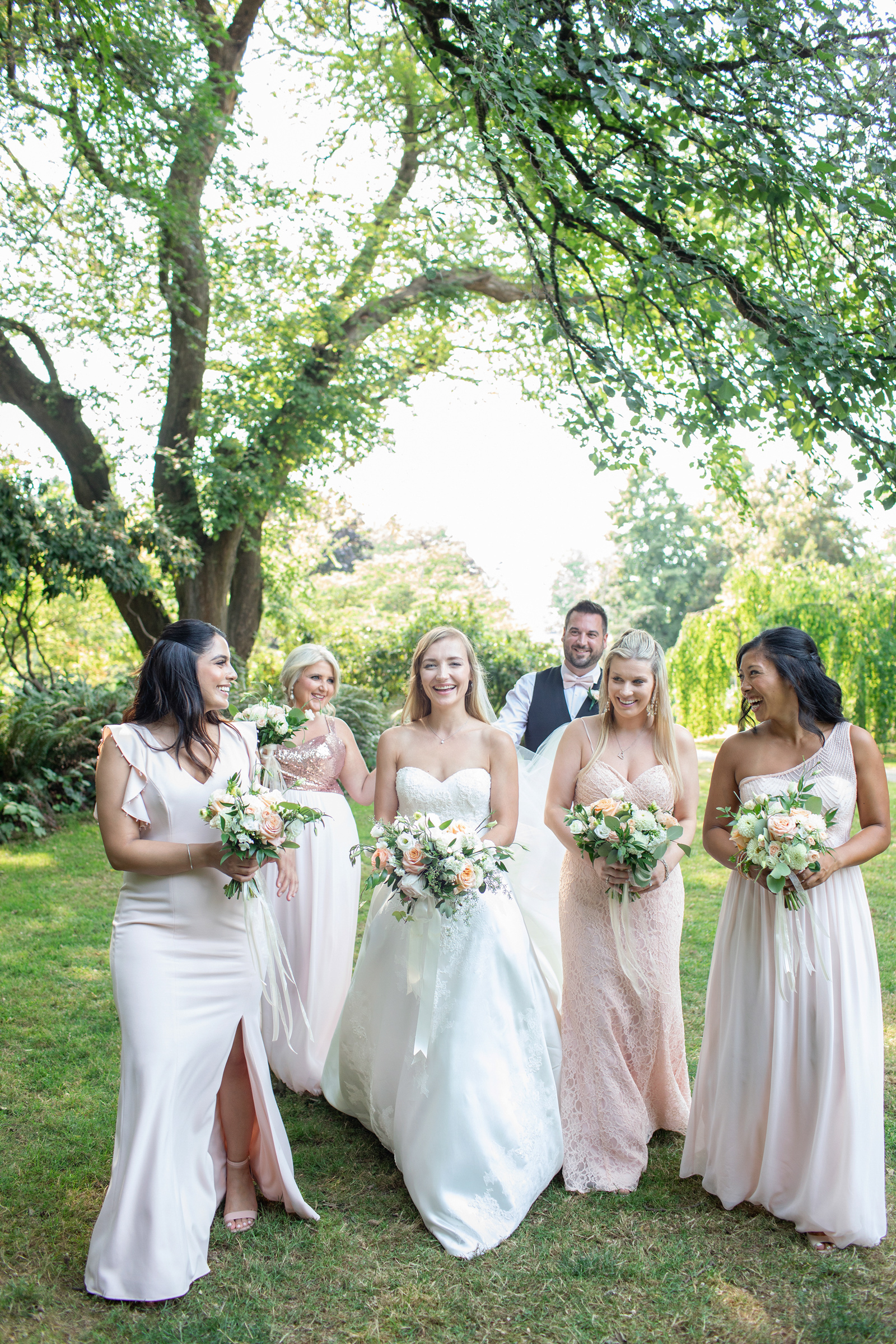 Bride walking with bridesmaids in a park on the Sunshine Coast BC.