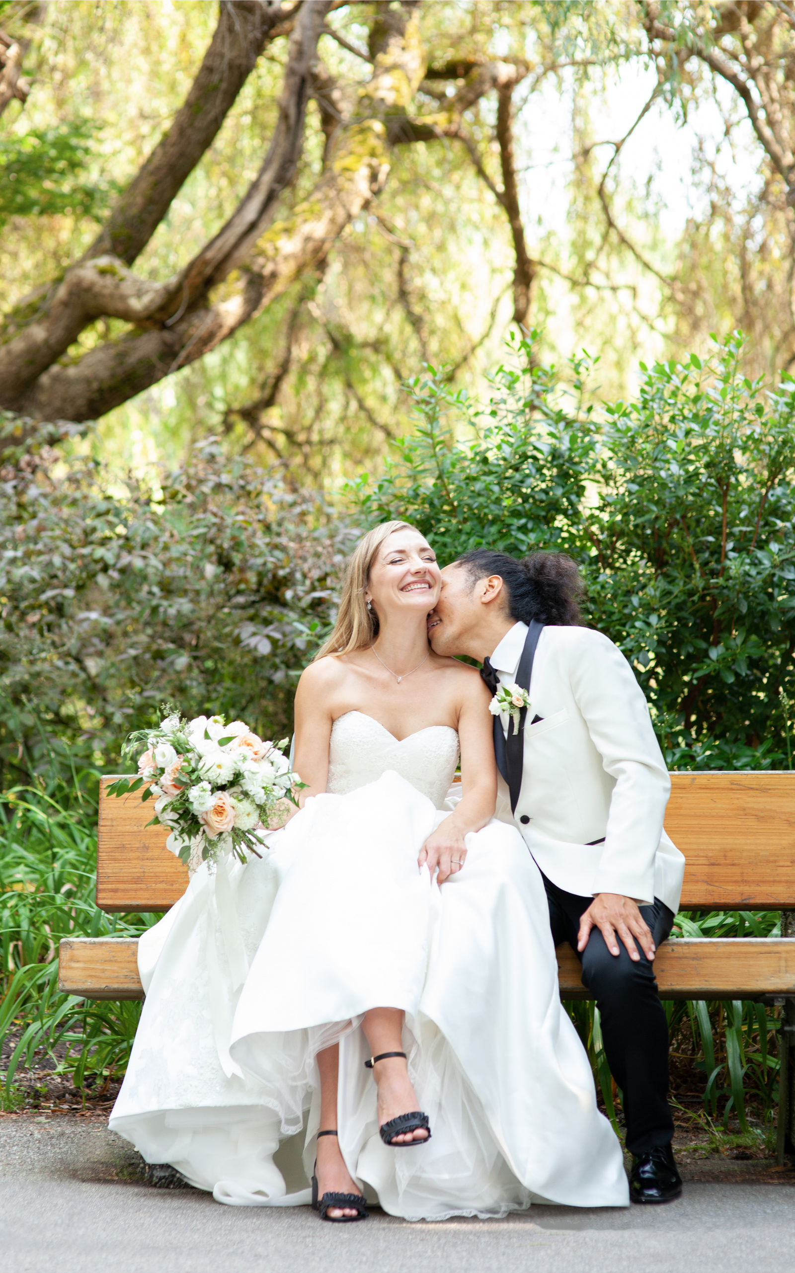 Groom kissing brides neck bride laughing